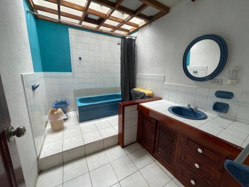 y baño con lavabo, aseo y espejo. en Hostal Pachamama Lodge, en Cuenca