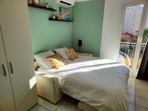 une chambre avec un lit avec des oreillers dessus dans l'établissement Studio proche plage et commerces, à Menton