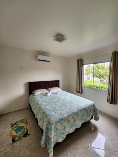 sypialnia z łóżkiem i dużym oknem w obiekcie Apartamento w mieście Florianópolis