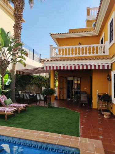a backyard with a pool and a house at Villa Granada Motril in Motril