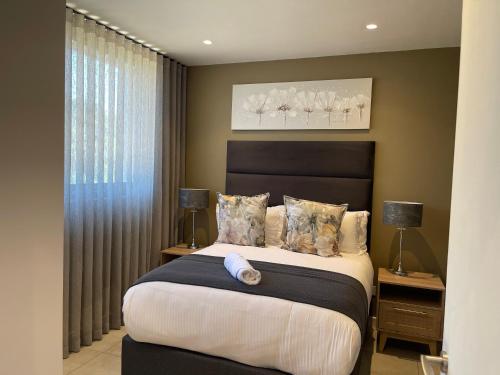 a bedroom with a large bed and a window at Zimbali Boulevard Suite 210 in Ballito