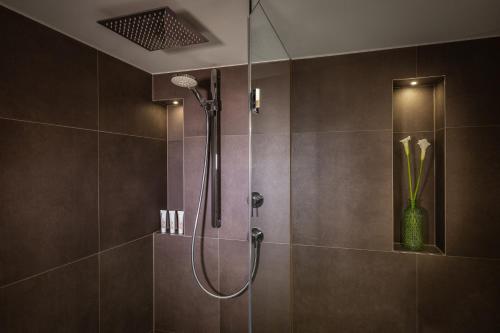 a shower with a glass door in a bathroom at Le Méridien Munich in Munich