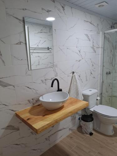 een witte badkamer met een wastafel en een toilet bij Tree House II in Setúbal
