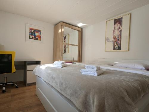 1 dormitorio con 1 cama grande y toallas. en Twin-Magnolias Condo with Garden, Parking & EV Station en Zagreb