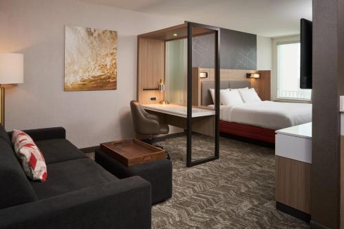 une chambre d'hôtel avec un canapé et un lit dans l'établissement SpringHill Suites by Marriott Fort Myers Estero, à Estero