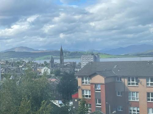 a view of a city with buildings and a church at Spacious one bedroom flat, entire property. in Greenock