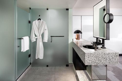 a bathroom with a sink and a robe hanging on a door at W Toronto in Toronto