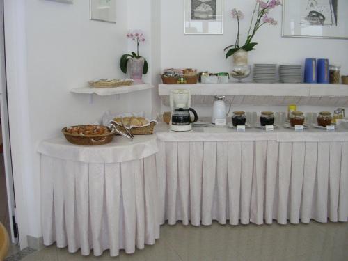 un buffet con tavoli bianchi con sopra cibo di Hotel Escorial a Cervia