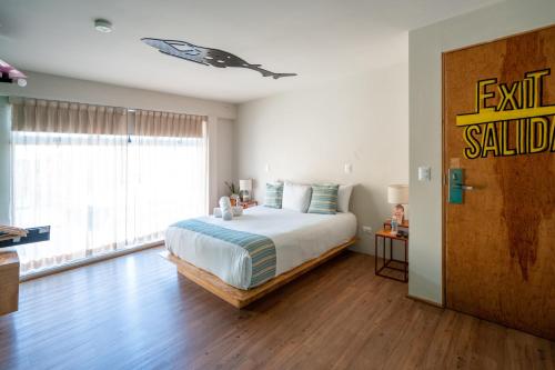 a bedroom with a bed and a large window at Mayan Monkey Cancun - Social Hotel in Cancún