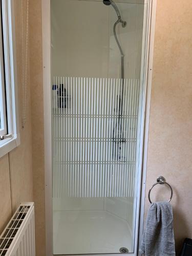 a shower with a glass door in a bathroom at Sunrise 132 in Winthorpe