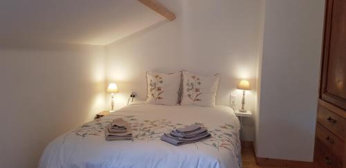Un dormitorio con una cama blanca con toallas. en Charmante maison de campagne en Nalliers