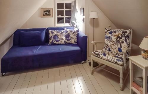 a blue couch and a chair in a room at Nice Home In Simrishamn in Simrishamn