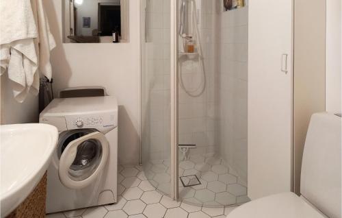 uma casa de banho com uma máquina de lavar roupa e um chuveiro em Beautiful Home In Simrishamn With Kitchen em Simrishamn