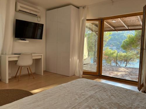 a bedroom with a bed and a desk and a window at Apartment by the sea Žirje with private heated hydromassage pool in Žirje