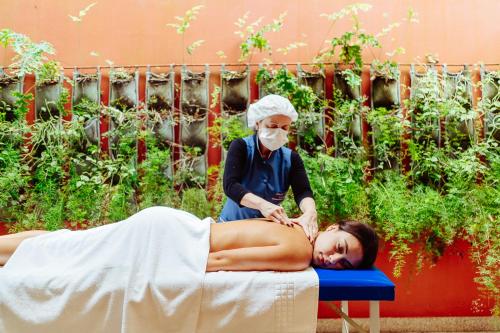 a woman getting a massage from a masseur at Hotel Reggia Catarina in Petrópolis