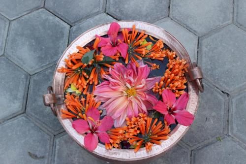 a wooden bowl filled with flowers on a floor at Hotel Riverside with Swimming pool in Sauraha