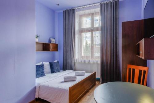 a small bedroom with a bed and a window at Apartamenty Krupówki in Zakopane