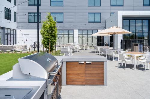 a outdoor kitchen with a grill and tables and chairs at Element San Jose Airport in San Jose