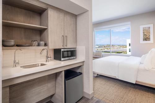 a kitchen with a sink and a bed in a room at Element San Jose Airport in San Jose