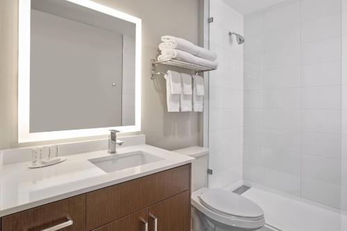a bathroom with a sink and a toilet and a mirror at TownePlace Suites by Marriott Edmonton Sherwood Park in Sherwood Park