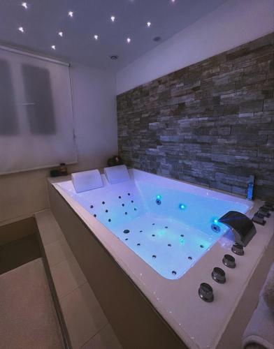 a hot tub in a room with a brick wall at Sweet Home in Erstein