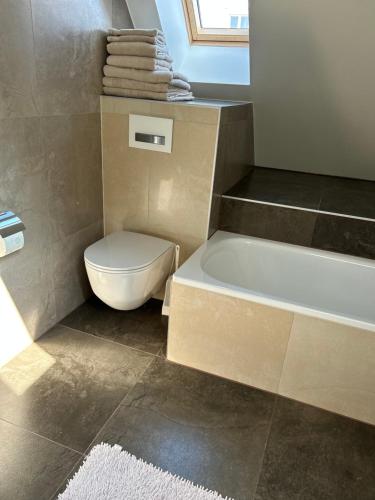 a bathroom with a toilet and a bath tub at Les Magniolas in Prilly