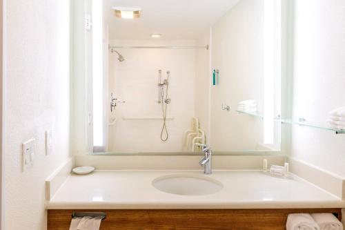 a white bathroom with a sink and a shower at SpringHill Suites Houston NASA/Seabrook in Seabrook