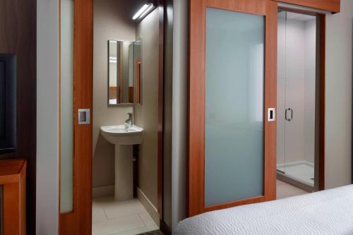 a bathroom with a sink and a toilet and a mirror at SpringHill Suites by Marriott Atlanta Airport Gateway in Atlanta