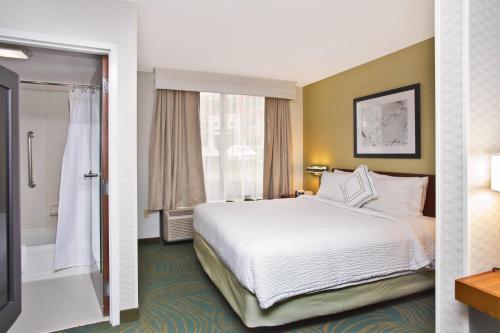une chambre d'hôtel avec un lit et une douche dans l'établissement SpringHill Suites by Marriott Chicago Southwest at Burr Ridge Hinsdale, à Burr Ridge