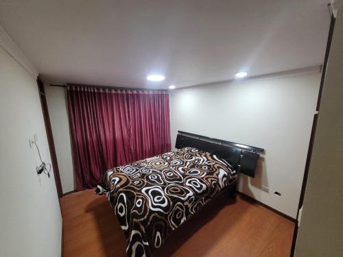 1 dormitorio con cama y cortina roja en Casa Grande con parqueadero en Ipiales