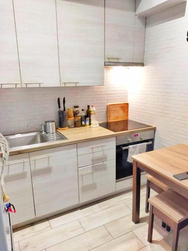 a kitchen with white cabinets and a sink and a table at TOM ROOM - Cracow City Centre in Krakow