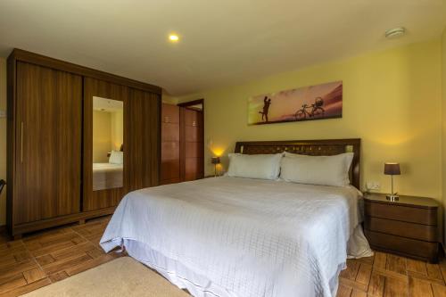 a bedroom with a large white bed and a mirror at Kings International Hotel in Rio das Flores