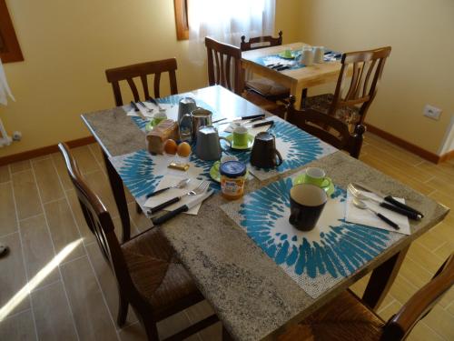 a dining room table with plates and utensils on it at B&B Giardino di Ro in Cazzago di Pianiga