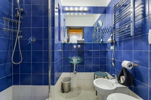 uma casa de banho em azulejos azuis com um lavatório e um WC em Lovely ROOMS VATICAN em Roma
