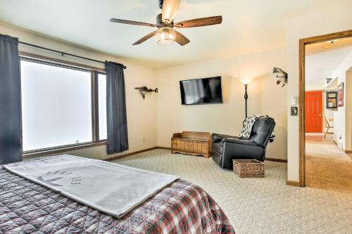 a bedroom with a bed and a chair and a tv at Fishing Haven Family Home on Indian Lake in Three Lakes