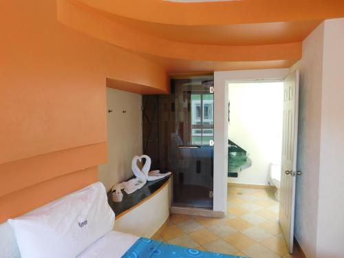 ein Schlafzimmer mit orangefarbener Decke, einem Bett und einem Zimmer in der Unterkunft Hotel Extasis in Mexiko-Stadt