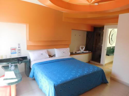 een slaapkamer met een blauw bed en een oranje plafond bij Hotel Extasis in Mexico-Stad