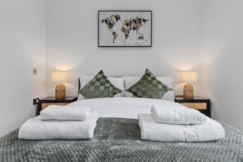 una camera con un letto bianco e 2 lampade di SERCASA - Appletree Court - Kingston a Kingston upon Thames