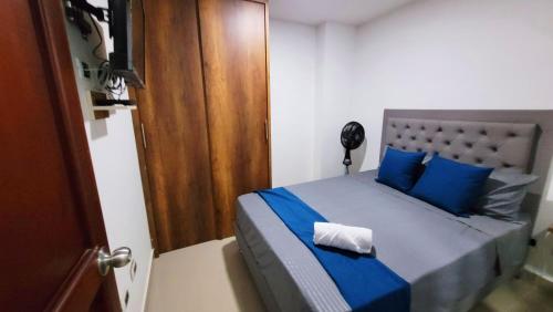 a bedroom with a bed with blue sheets and blue pillows at ANDALIVING NIQUIA APARTAMENTO in Bello