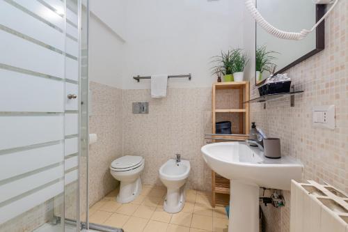Un baño con lavabo, inodoro y ducha. en Julius Caesar Home, en Roma