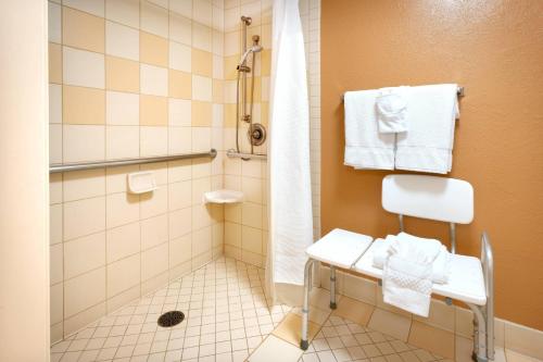 y baño con ducha, silla y toallas. en Fairfield Inn by Marriott Provo en Provo