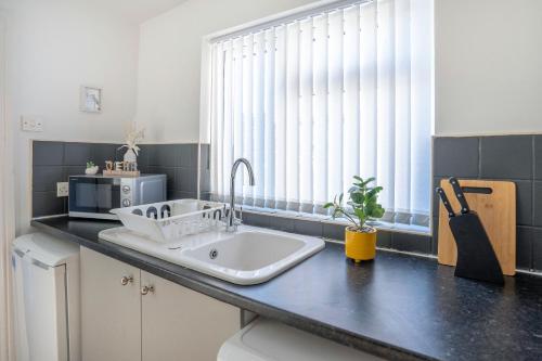a kitchen counter with a sink and a window at Spacious 3 Bed Flat-Free Parking in Gateshead