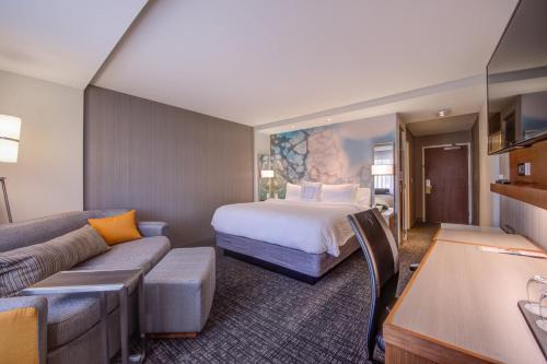 una camera d'albergo con letto e divano di Courtyard by Marriott St Louis Chesterfield a Chesterfield