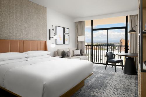 a hotel room with a bed and a desk and a table at Sheraton Park Hotel at the Anaheim Resort in Anaheim