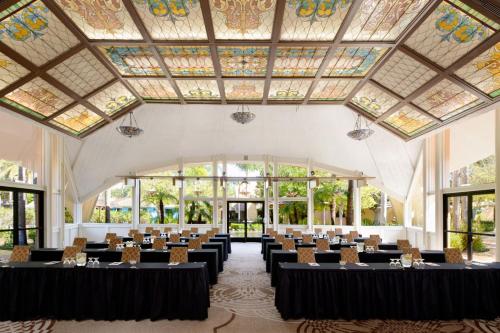 a hall with tables and chairs in a room with windows at Sheraton Park Hotel at the Anaheim Resort in Anaheim