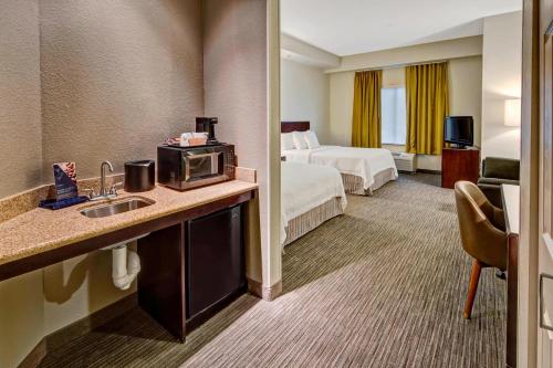 a hotel room with a sink and a bedroom at SpringHill Suites by Marriott Naples in Naples