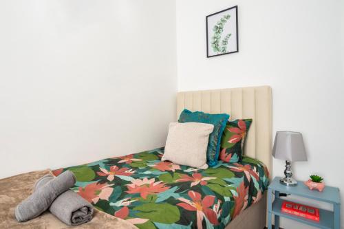 a bedroom with a bed with a flowery comforter at Spacious 3 Bed Flat-Free Parking in Gateshead