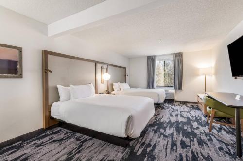 グリーンズボロにあるFairfield by Marriott Inn & Suites Greensboro Coliseum Areaのベッド2台とデスクが備わるホテルルームです。