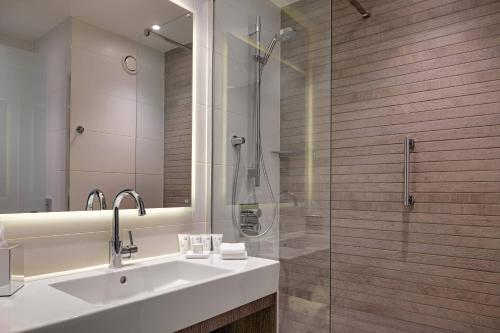 a bathroom with a sink and a glass shower at AC Hotel by Marriott Manchester City Centre in Manchester