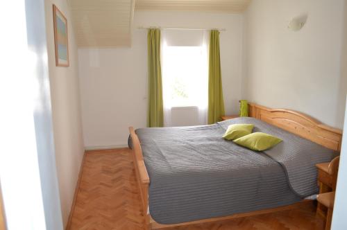 a bedroom with a bed with two yellow pillows on it at Guest House Kolarin in Slano